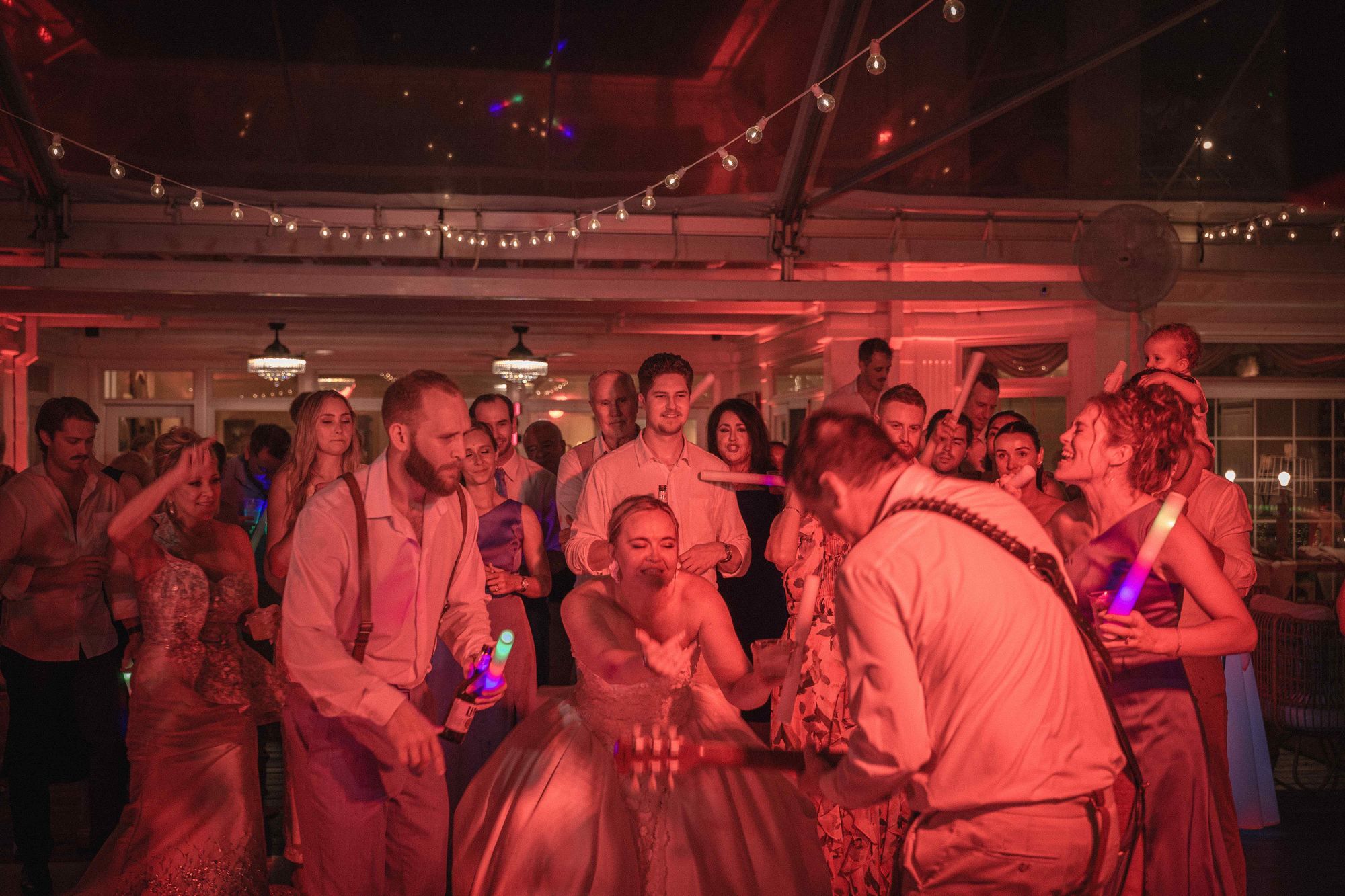 The same dance floor and the same string lighting, the room washed in warm red